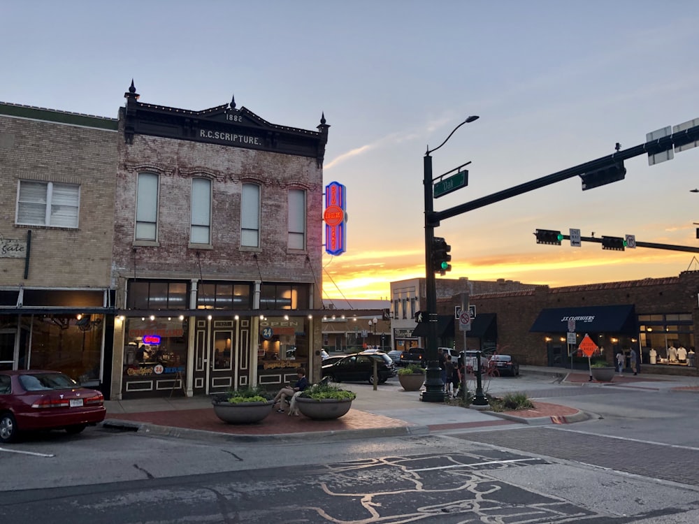 A historic downtown street corner at sunset with brick storefronts and traffic signals.
