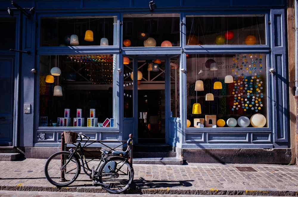 A tidy small-business storefront with large display windows and a bicycle parked on the sidewalk outside.